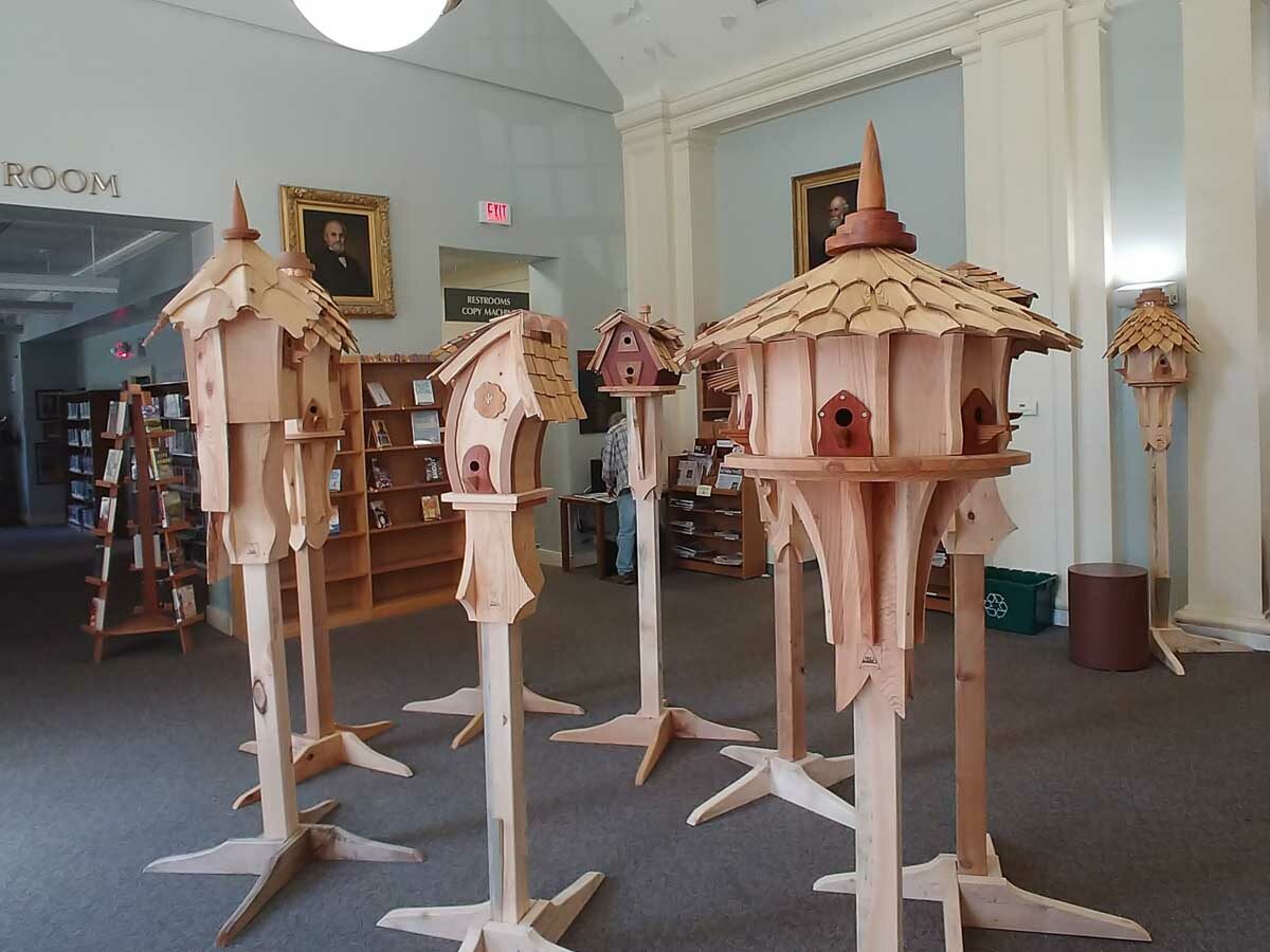 A collection of Eric's sculptural birdhouses set on stands.